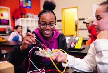 Young Black girl working on a circuit board