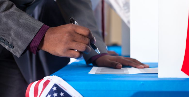 Closeup of man's hand while voting in election vote booth.